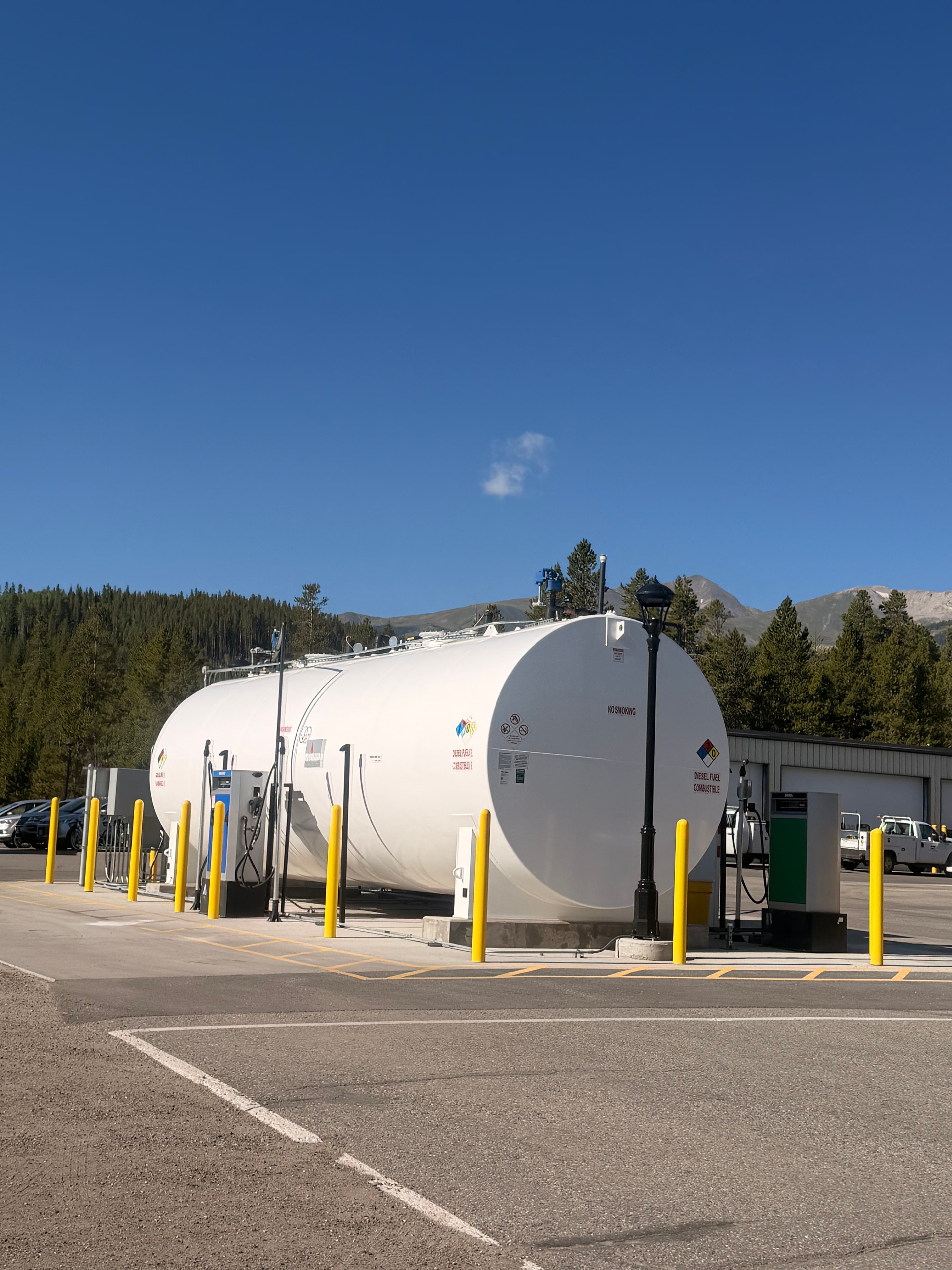 Large aboveground diesel fuel storage tank at mountain location with Colorado Rockies in background