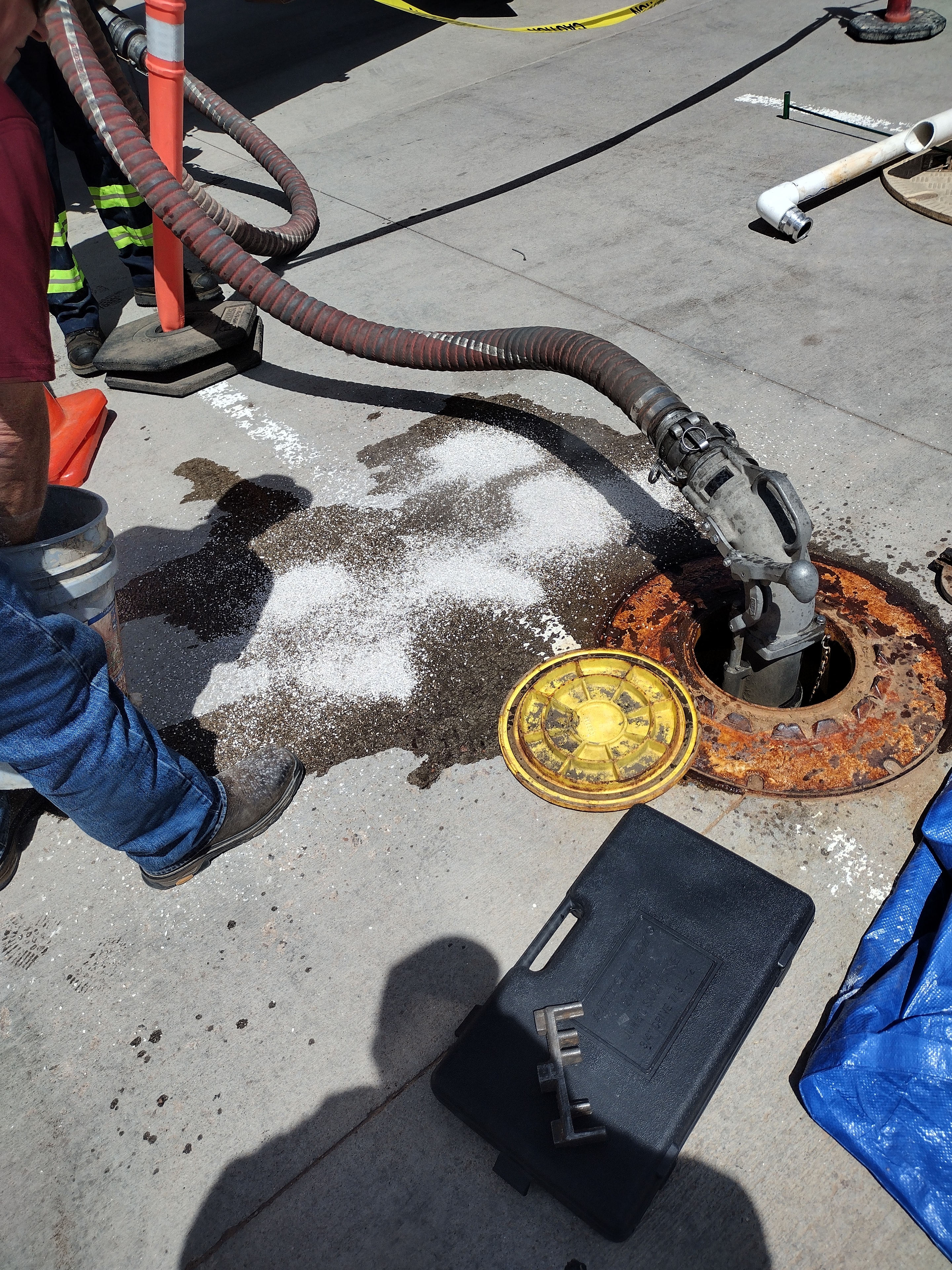 Underground diesel fuel tank access with delivery hoses connected and safety cones in place