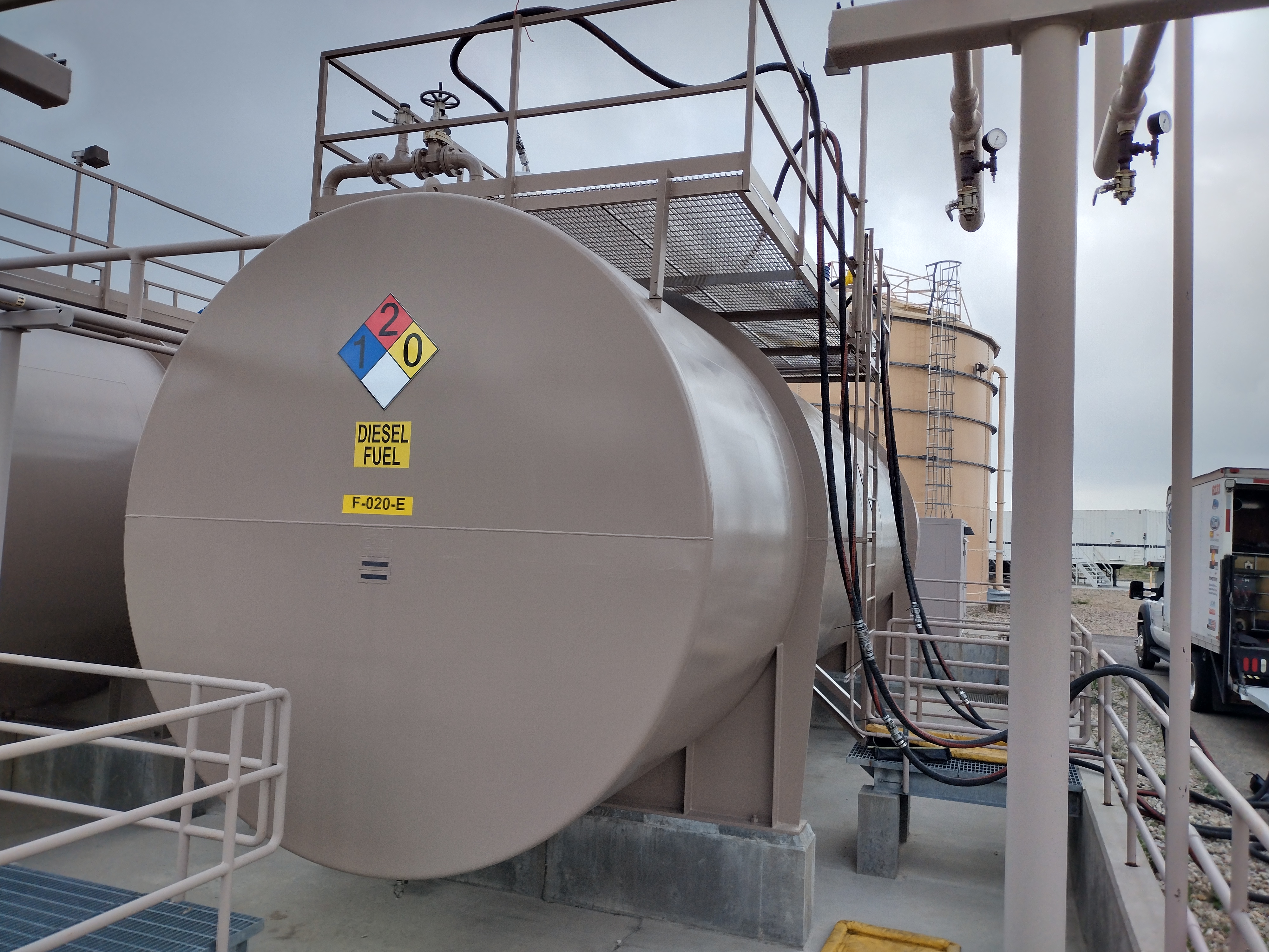 Large aboveground diesel fuel storage tank with NFPA hazmat placard at industrial facility