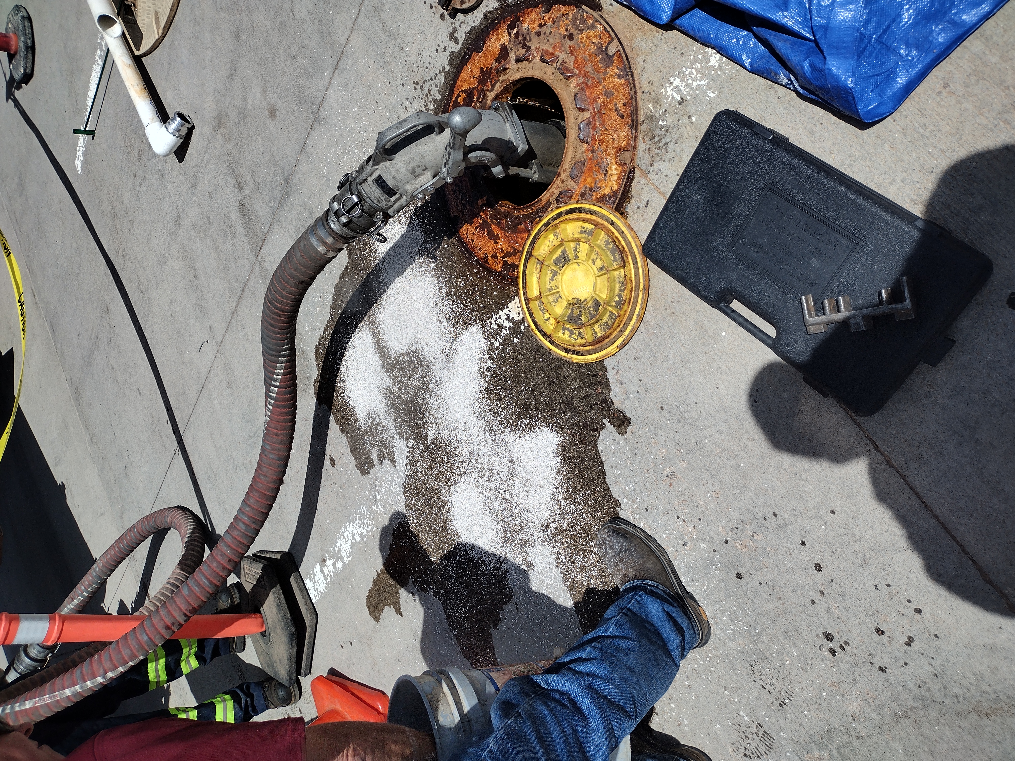 Underground diesel fuel tank access with delivery hoses connected and safety cones in place