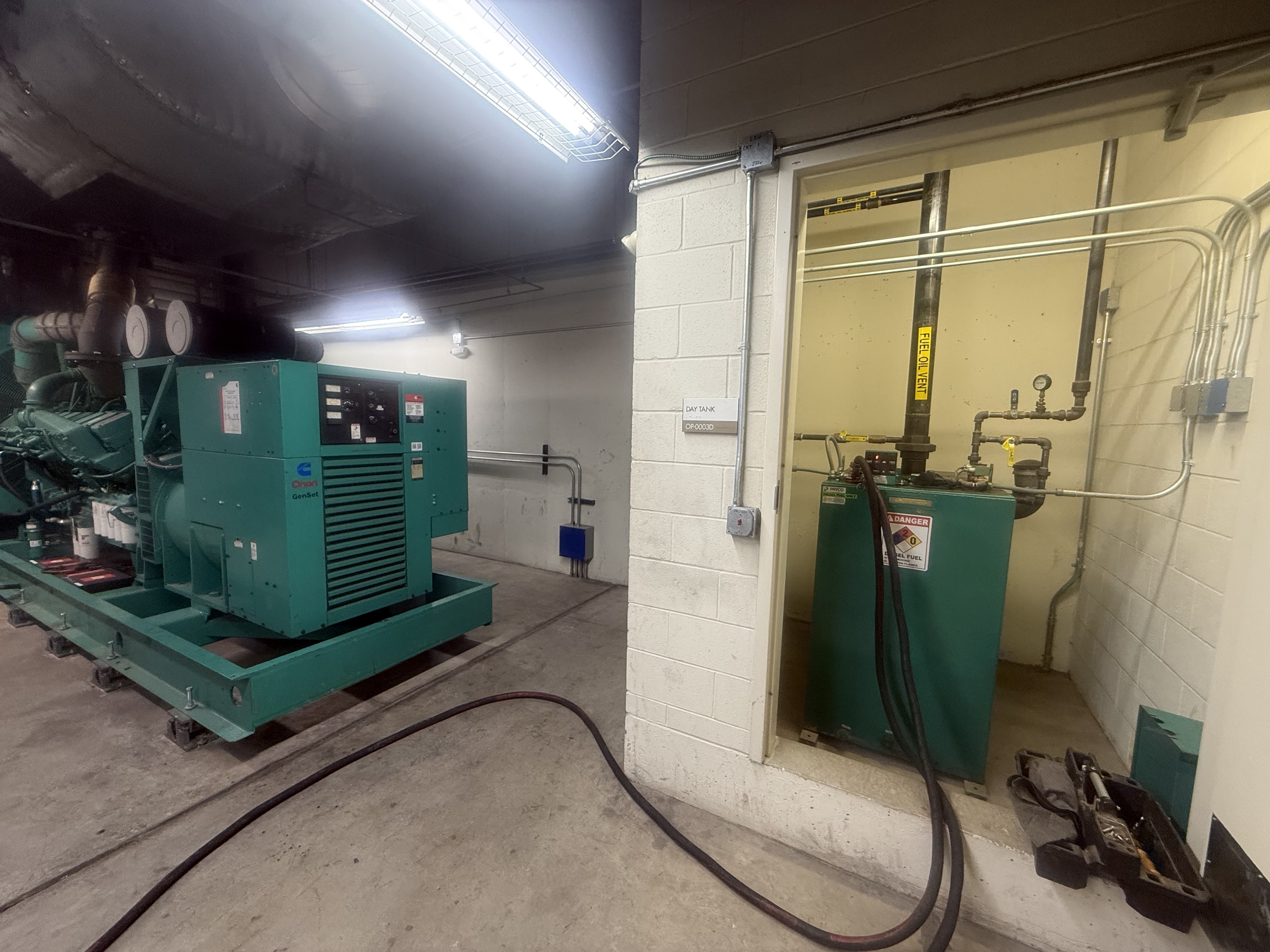 Cummins Onan GenSet with day tank in interior mechanical room, delivery hose connected